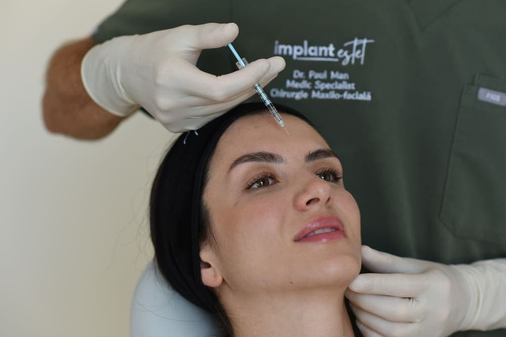 Dr. Paul Man injectând toxină botulinică la nivelul frunții unei paciente