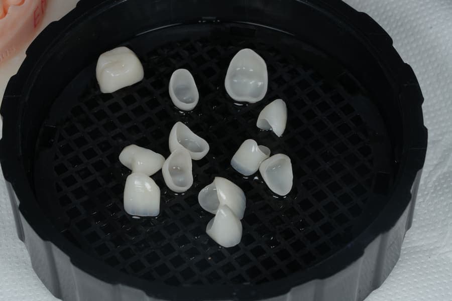 Fațete ceramice așezate într-un suport, pregătite pentru cimentare