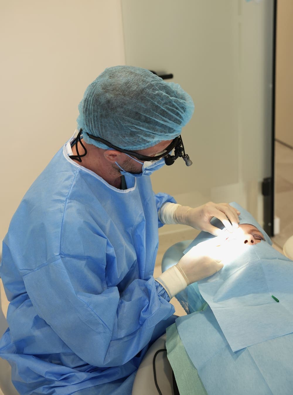 Dr. Paul Man, în echipament chirurgical steril și cu lupe de mărire, în timpul unei blefaroplastii