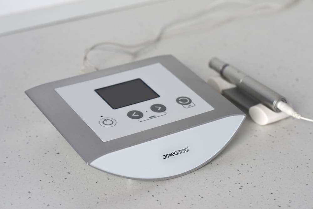 Dispozitivul de microneedling medical folosit în clinică, cu unitatea de control și piesa de mână